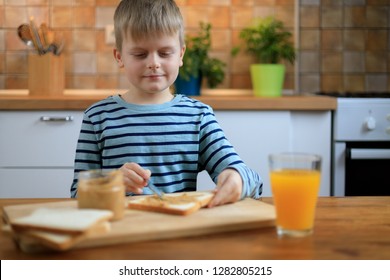 Boy Making A Sandwich With Peanut Butter On The Kitchen