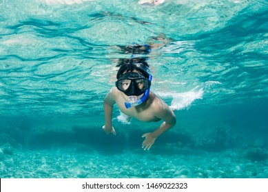 Boy with mask snorkeling in clear water. - Powered by Shutterstock