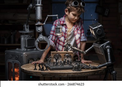 Boy Mechanic Looks Like Two Robots Play A Game Of Chess In The Studio In The Evening