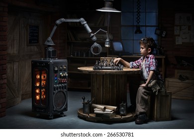 Boy Mechanic Robot Helper Playing Chess In The Studio In The Evening