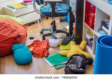 Boy messy bedroom with clothes and colorful pillows on the floor