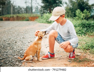 Boy met a little homeless puppy on the street