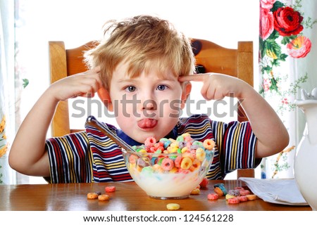 Boy misbehaving while eating breakfast cereal