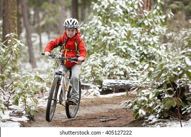 A Boy Mountain Biking In The Snow