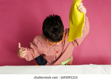 Boy, With Multiple Disabilities, With Glasses, With A School Gown, Takes Rubber To Do A Craft Activity.