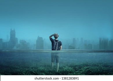 
A boy observes a city in a world submerged by water. Global warming, melting of arctic ices or Great Flood concept. - Shutterstock ID 1381283891