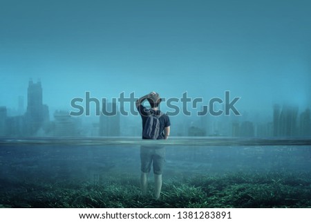 
A boy observes a city in a world submerged by water. Global warming, melting of arctic ices or Great Flood concept.