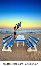 Boy On The Beach Holding Greek Flag Over The Sunset