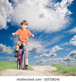 Boy on a bicycle on a background of blue sky
