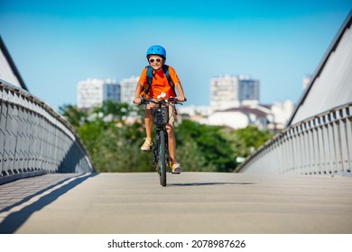 Boy on the bicycle cycle over bridge on bike lane with city buildings on background, smiling - Powered by Shutterstock