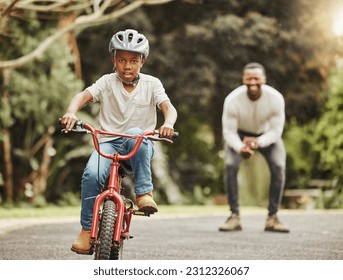 Boy on bicycle, father cheers and learning cycling with help, helmet for safety and family in park. Support, motivation and trust, black man and young kid outdoor, teaching and learn bike riding - Powered by Shutterstock