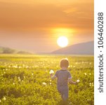 boy on a field in sunset