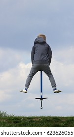 Boy On Pogo Stick Jumping Up And Down