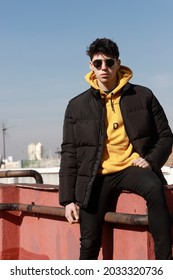 
Boy On Rooftop Dressed In Winter With Sunglasses And A Blue Sky