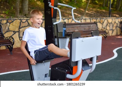 boy on street simulator in outdoor park. sporty young teen life. sports ground outside. child is exercising