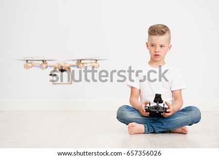 Boy is operating the drone by remote control.