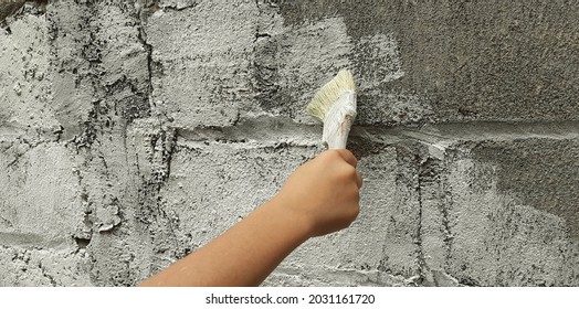 The Boy Painting Grey Brick Wall With Brush Paint