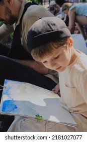 Boy Painting On Easel, Father Next To Him, Smiling