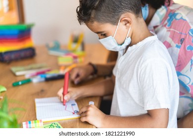 Boy Painting In Preschool Classroom Wearing Face Protective Mask - Back To School During Coronavirus Outbreak Concept - Focus On Kid's Ear