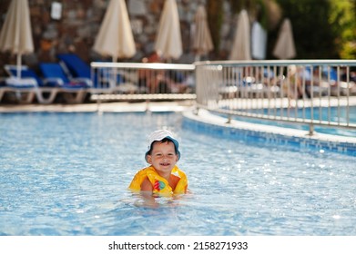 Boy In Panama And Child Life Vest Bathes In The Pool.