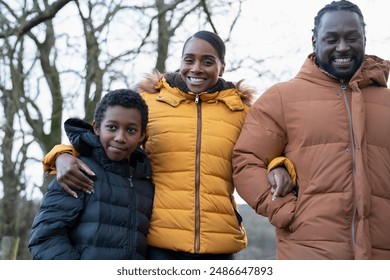 Boy with parents in winter jackets walking in rural setting - Powered by Shutterstock