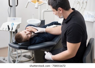 Boy Patient With Toothache Complaining To Pediatric Dentist At Dental Clinic Office. Medicine, Dentistry And Health Care Concept. Dental Equipment