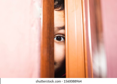 Boy Peeking Behind A Door