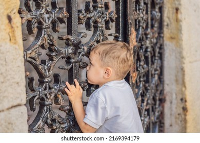 Boy peeking through a hole in the fence
