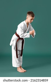 Boy Performing Ritual Bow Before Practicing Karate On Green Background