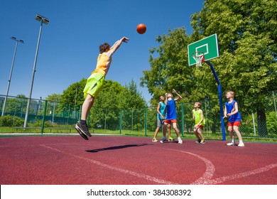 Boy Performs Foul Shot At Basketball Game On The Playground During Sunny Summer Day