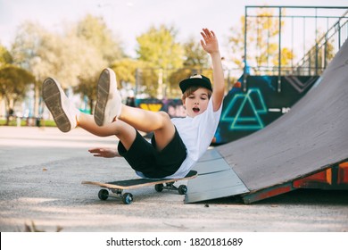 A boy performs tricks on a skateboard in a special area in the Park. A boy falls off a skate while riding in a skatepark. The child is having fun. - Powered by Shutterstock