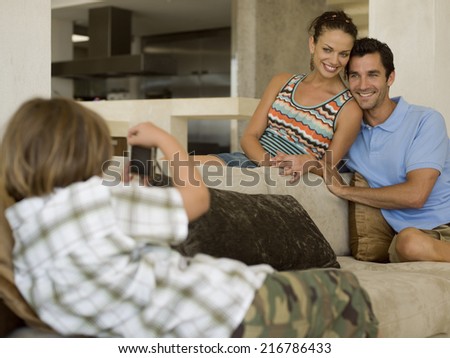 Boy photographing his parents