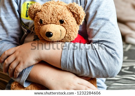  Boy   in pijamas huggig a teddy bear toy