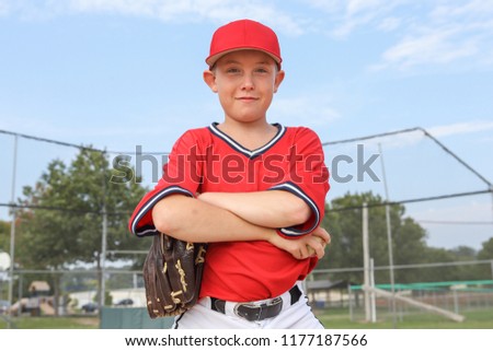 Boy pitcher smiling and holding a baseball