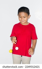 boy play the Lato-lato game which is a type of traditional game that is commonly found in Indonesia - Shutterstock ID 2249312421
