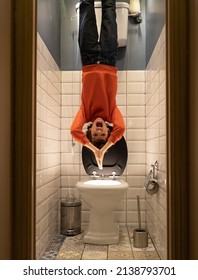 Boy playfully diving into the toilet. Fun and jokes concept.