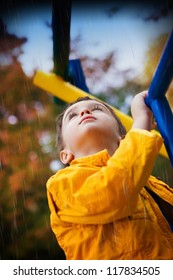 Boy at the playground looks at the rainy sky - Shutterstock ID 117834505