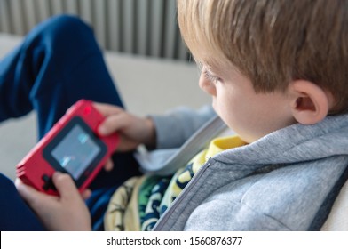 Boy playing 8 bit console game at home