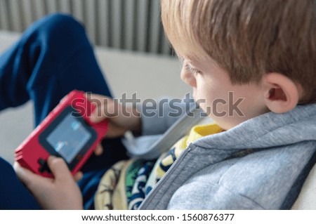 Boy playing 8 bit console game at home