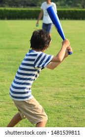 A Boy Playing Baseball In The Park