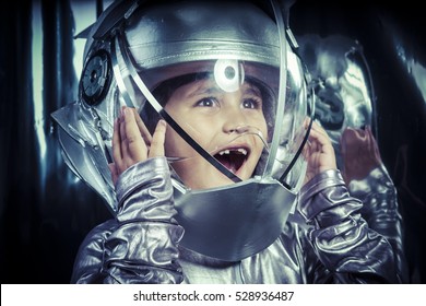 Boy playing to be an astronaut with space helmet and metal suit