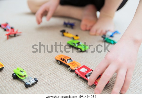 boy playing\
with car collection on carpet.Child hand play. Transportation,\
airplane, plane and helicopter toys for children, miniature models.\
Many cars for little boys.