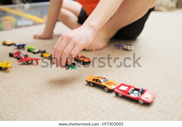 boy playing\
with car collection on carpet.Child hand play. Transportation,\
airplane, plane and helicopter toys for children, miniature models.\
Many cars for little boys.