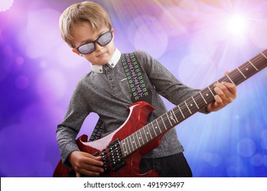 Boy Playing Electric Guitar On Stage In Rock Music School Talent Show