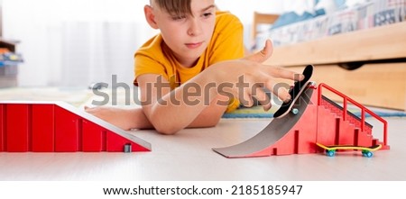 Boy Playing Fingerboard with Ramp