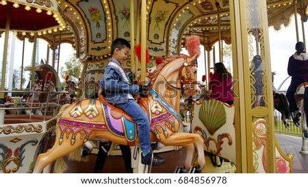 Boy playing merry go round horse