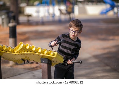 Boy Playing Musical Instrument Xylophone Outside At The Park