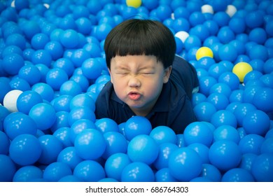 A Boy Is Playing In The Plastic Ball Land.