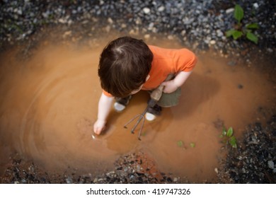 Boy Playing in Puddle