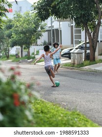 A Boy Playing Soccer On The Street In Front Of His House, Jombang, East Java INDONESIA, 10th June 2021